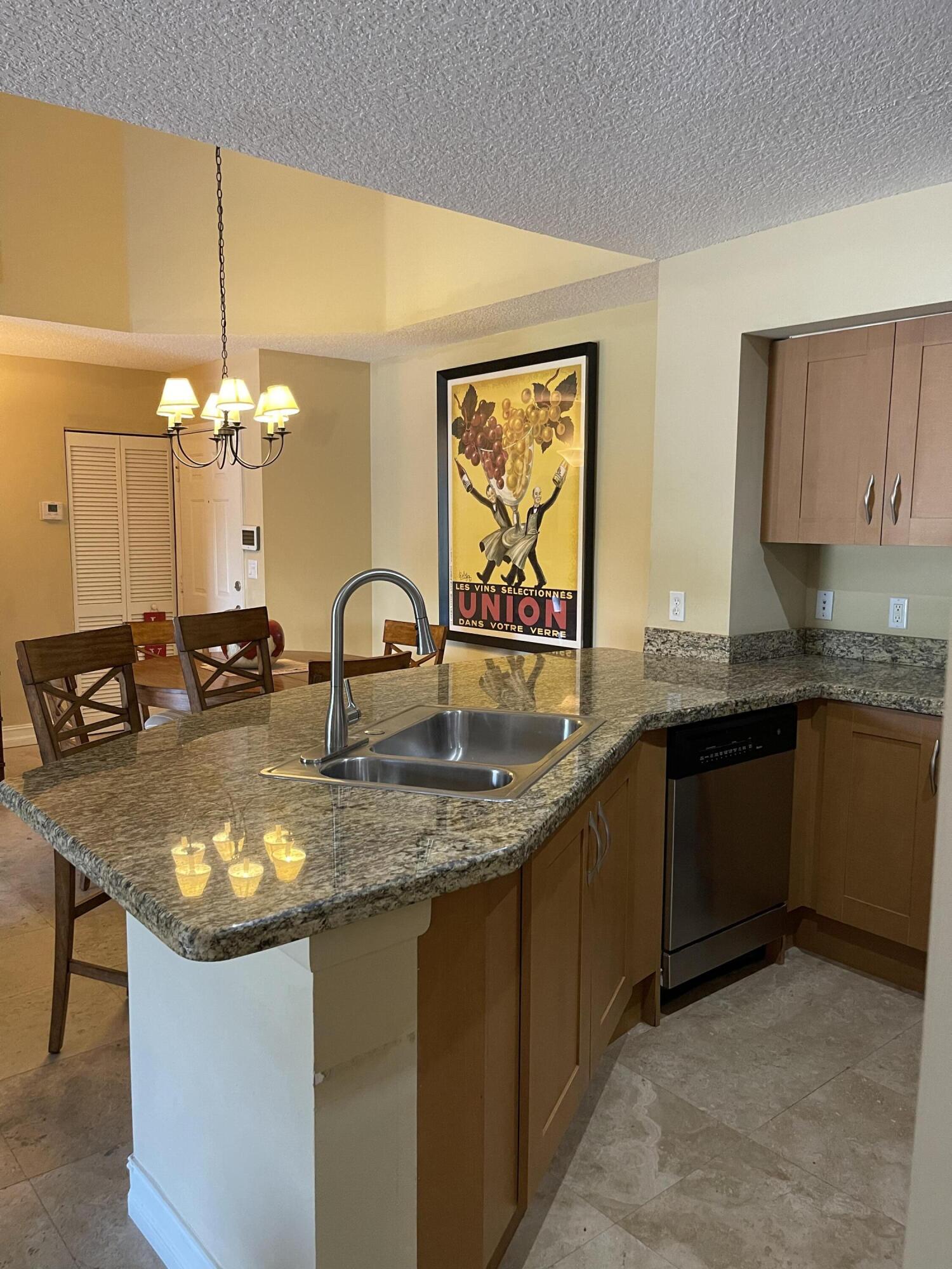 3111 Clint Moore Road, Unit 205 Boca Raton, FL 33496 - Photo 16 of 35 a kitchen with kitchen island granite countertop a sink cabinets and window