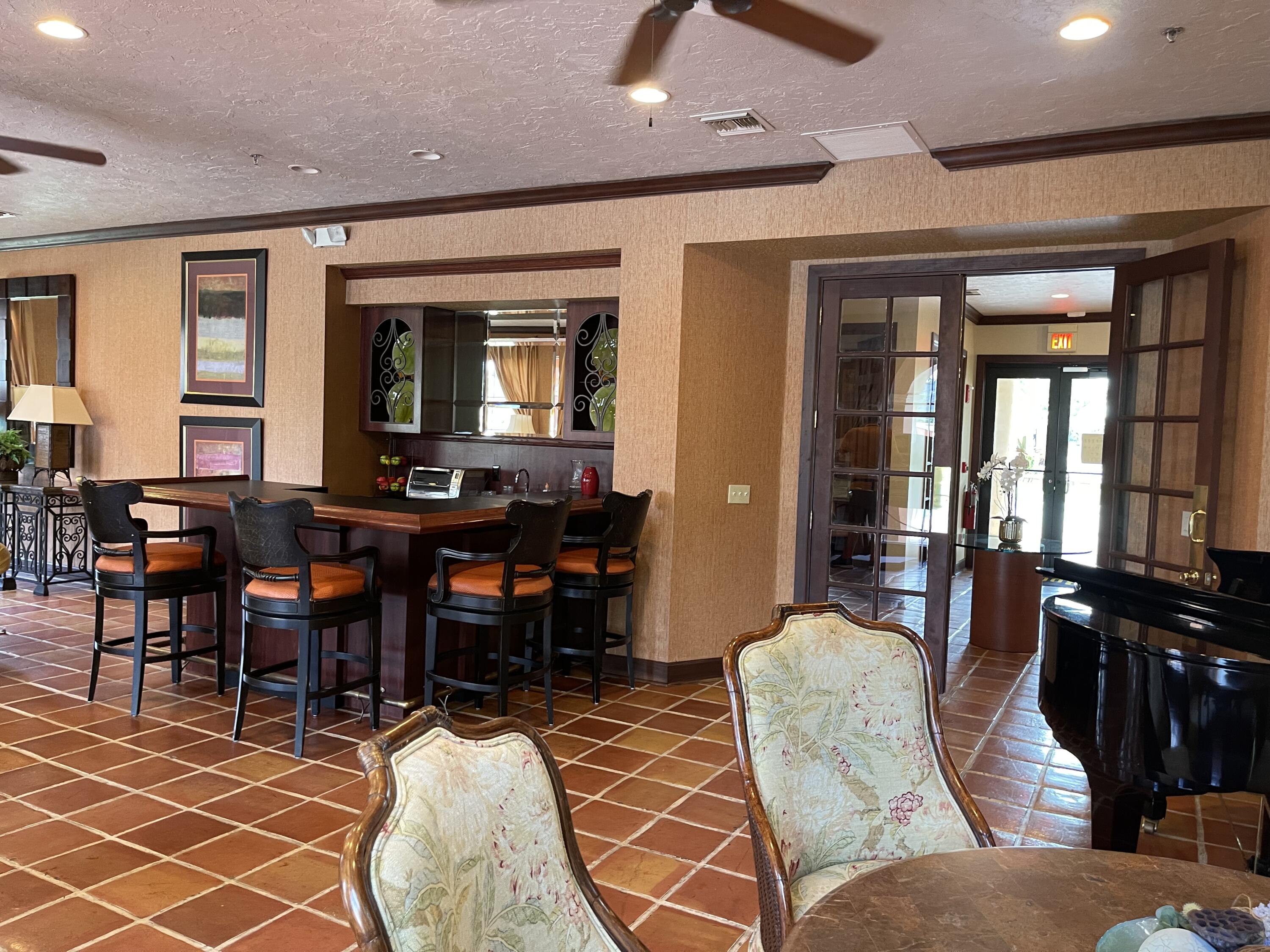 3111 Clint Moore Road, Unit 205 Boca Raton, FL 33496 - Photo 31 of 35 a living room with furniture a dining table and a fireplace