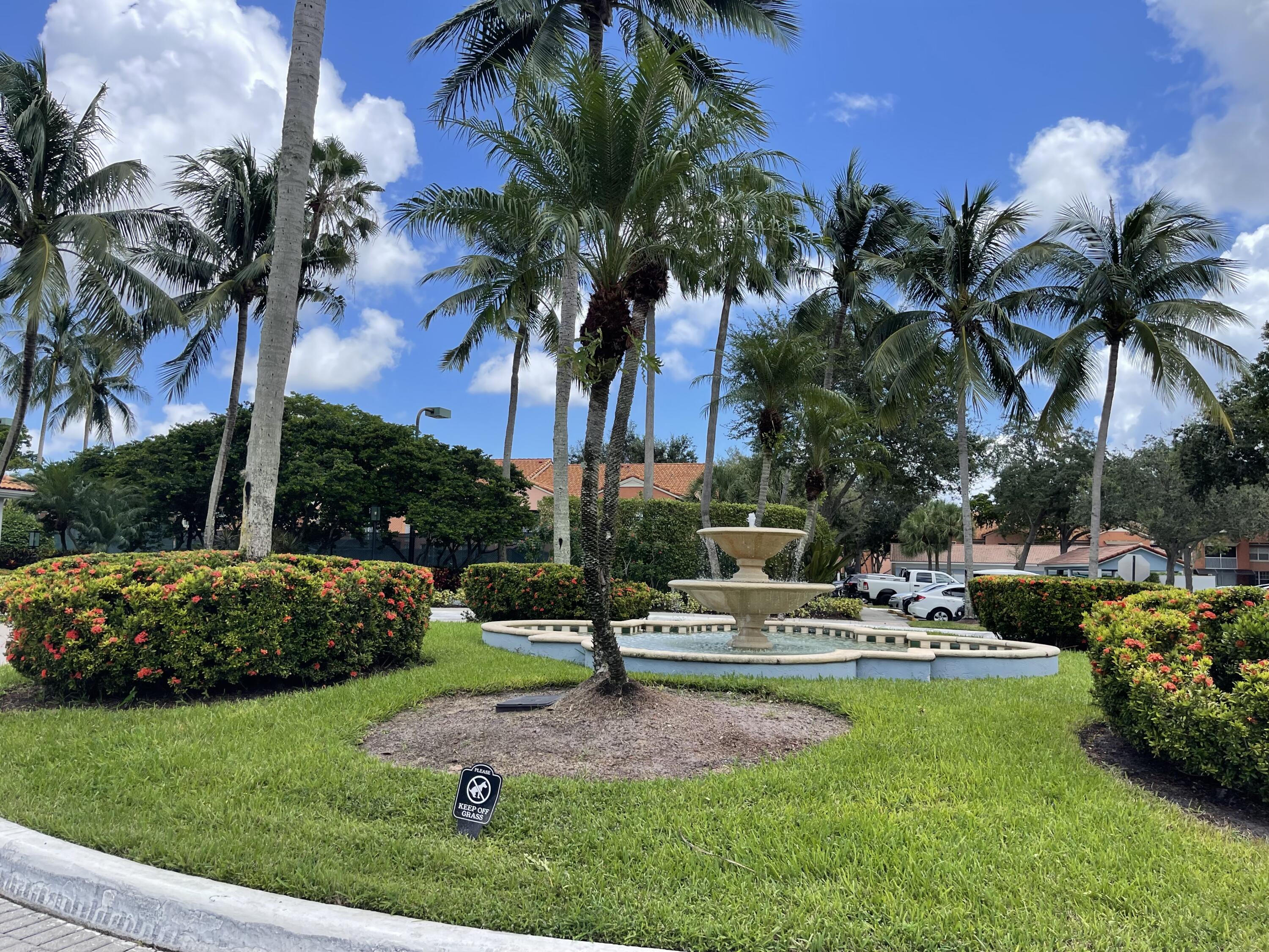 3111 Clint Moore Road, Unit 205 Boca Raton, FL 33496 - Photo 8 of 35 a view of a swimming pool with lawn chairs under palm trees