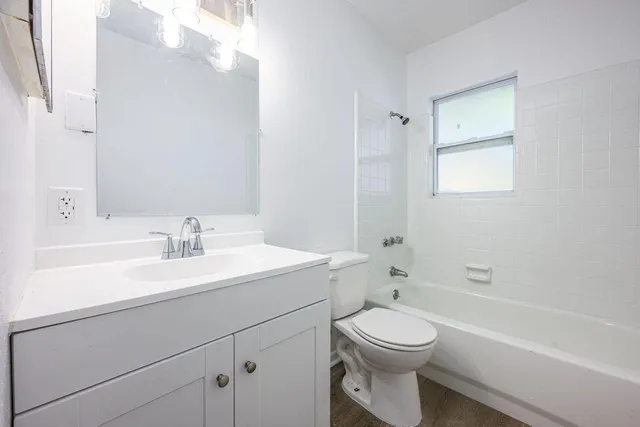 a bathroom with a toilet a sink a mirror and a bathtub