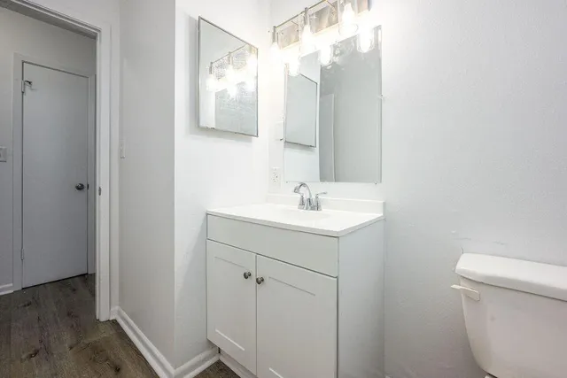 a bathroom with a sink mirror vanity and toilet