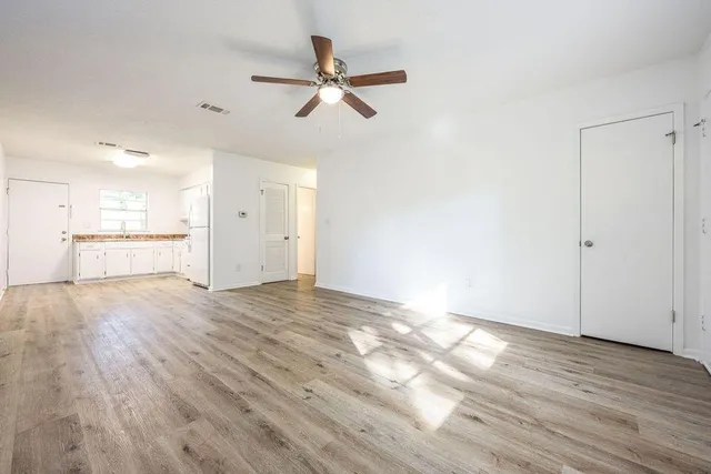 a view of a kitchen with wooden floor and a ceiling fan