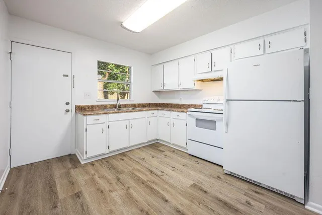 a kitchen with white cabinets and white appliances
