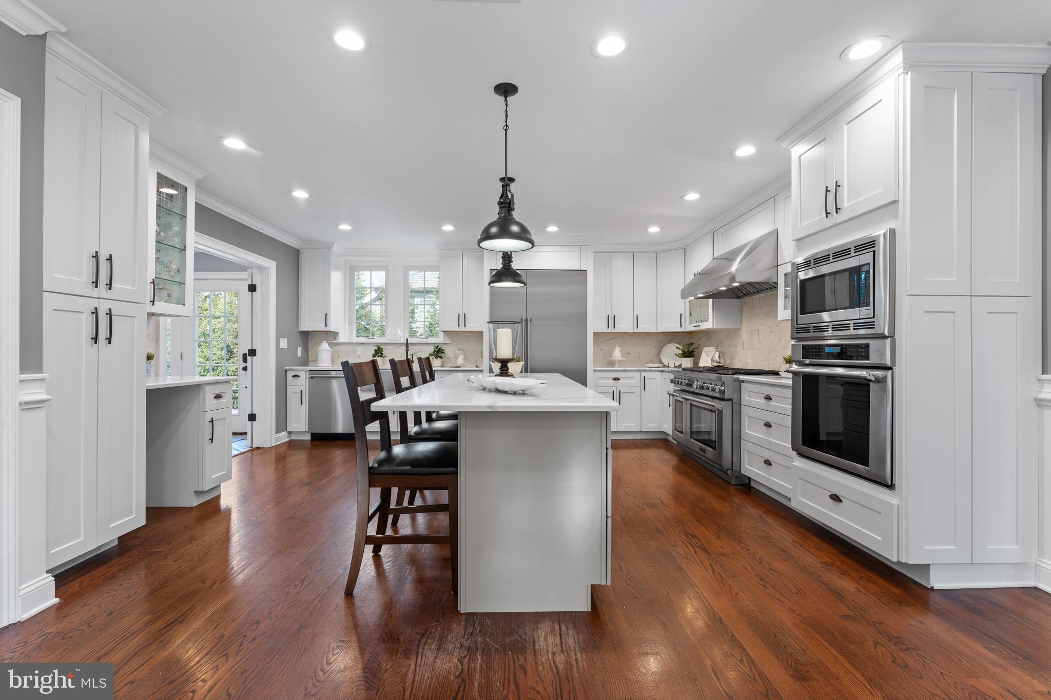 334 Fairhill Road Wynnewood, PA 19096 - Photo 6 of 45 a kitchen with stainless steel appliances kitchen island granite countertop a stove top oven a sink dishwasher a refrigerator and a dining table with wooden floor