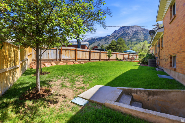 4245 3320 East Holladay, UT 84124 - Photo 40 of 51 Expansive backyard featuring a manicured lawn, established trees, and natural wood fencing