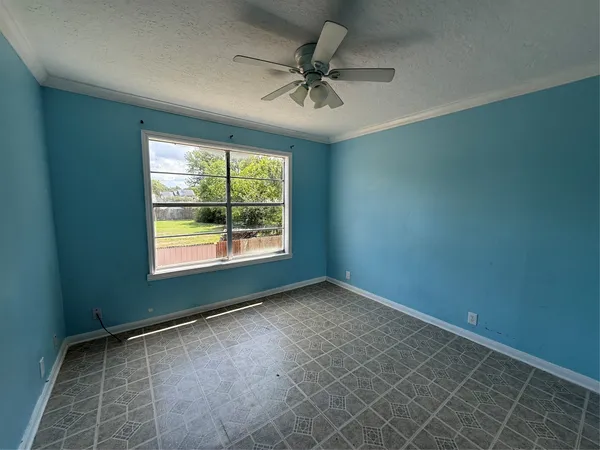 an empty room with a window and a fan