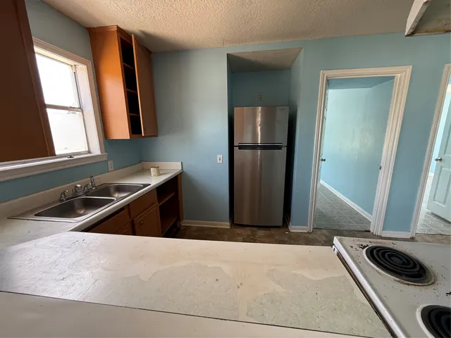 a kitchen with a sink stove and refrigerator