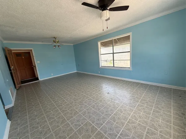 an empty room with windows and fan