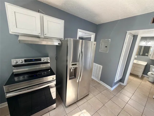 a kitchen with stainless steel appliances a refrigerator and a stove top oven