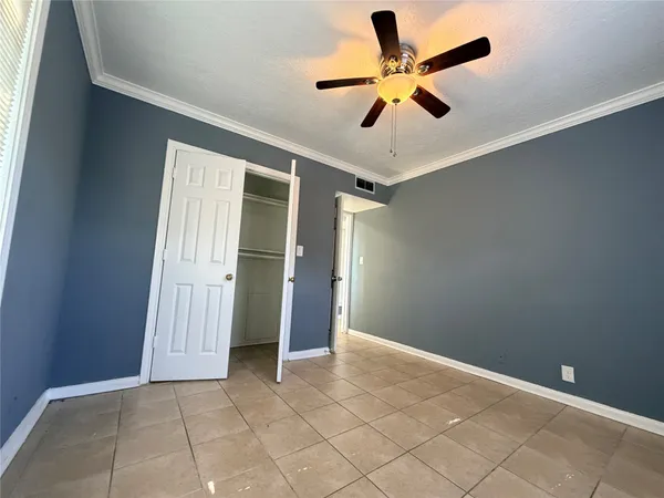 an empty room with closet and ceiling fan