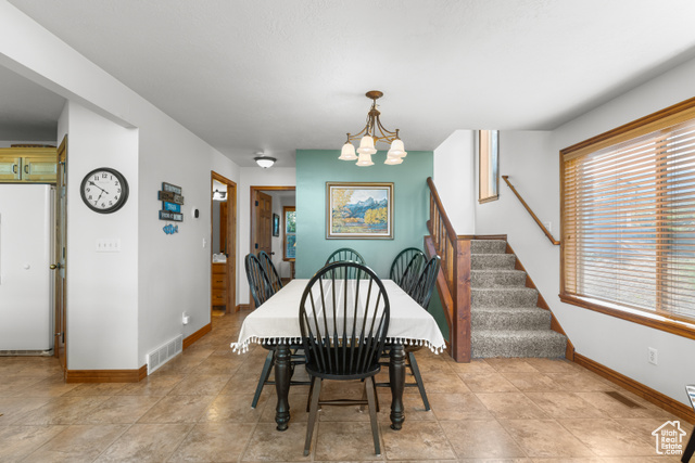 1340 Trapper Loop Garden City, UT 84028 - Photo 13 of 35 Dining area featuring a chandelier and stairway