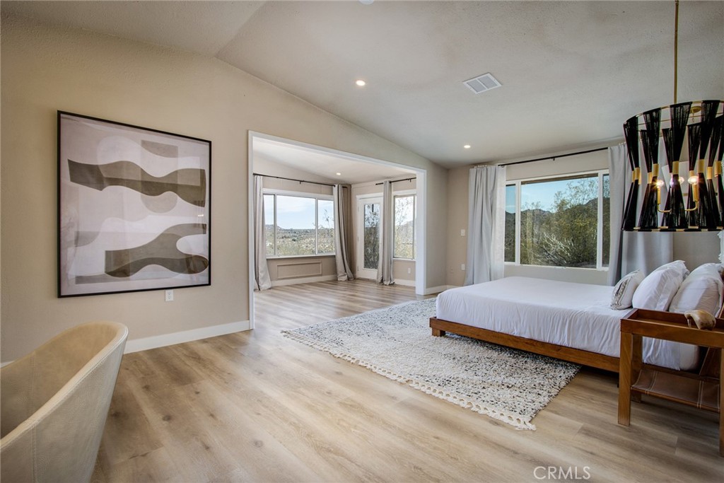 9073 Tortuga Trail Joshua Tree, CA 92252 - Photo 17 of 39 a spacious bedroom with a bed and glass windows