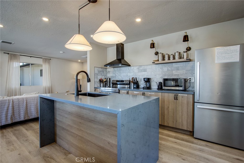 9073 Tortuga Trail Joshua Tree, CA 92252 - Photo 10 of 39 a kitchen with stainless steel appliances a sink a stove a refrigerator and wooden floor