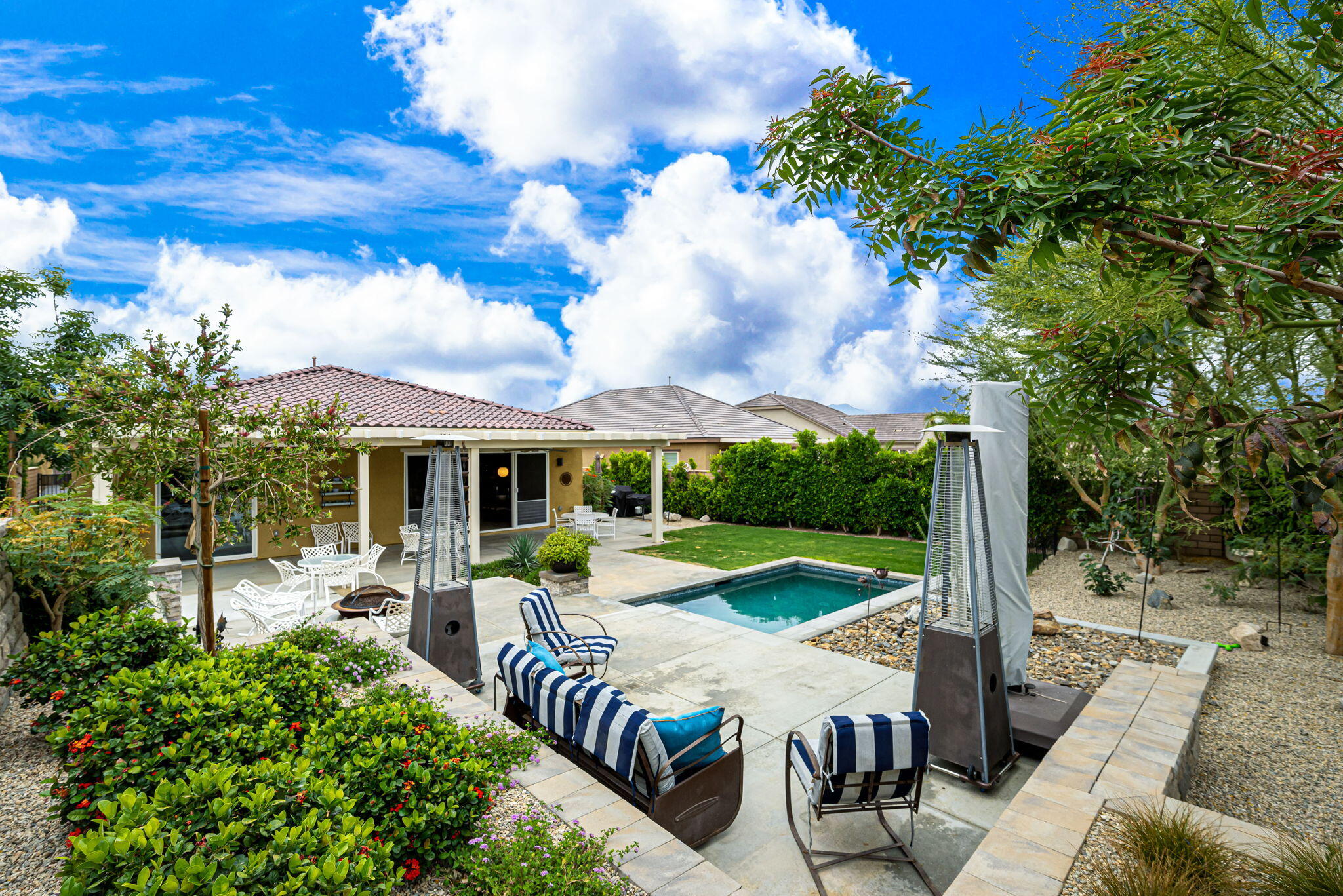 85568 Brovello Drive Indio, CA 92203 - Photo 31 of 50 a view of a patio with table and chairs potted plants with wooden floor and fence