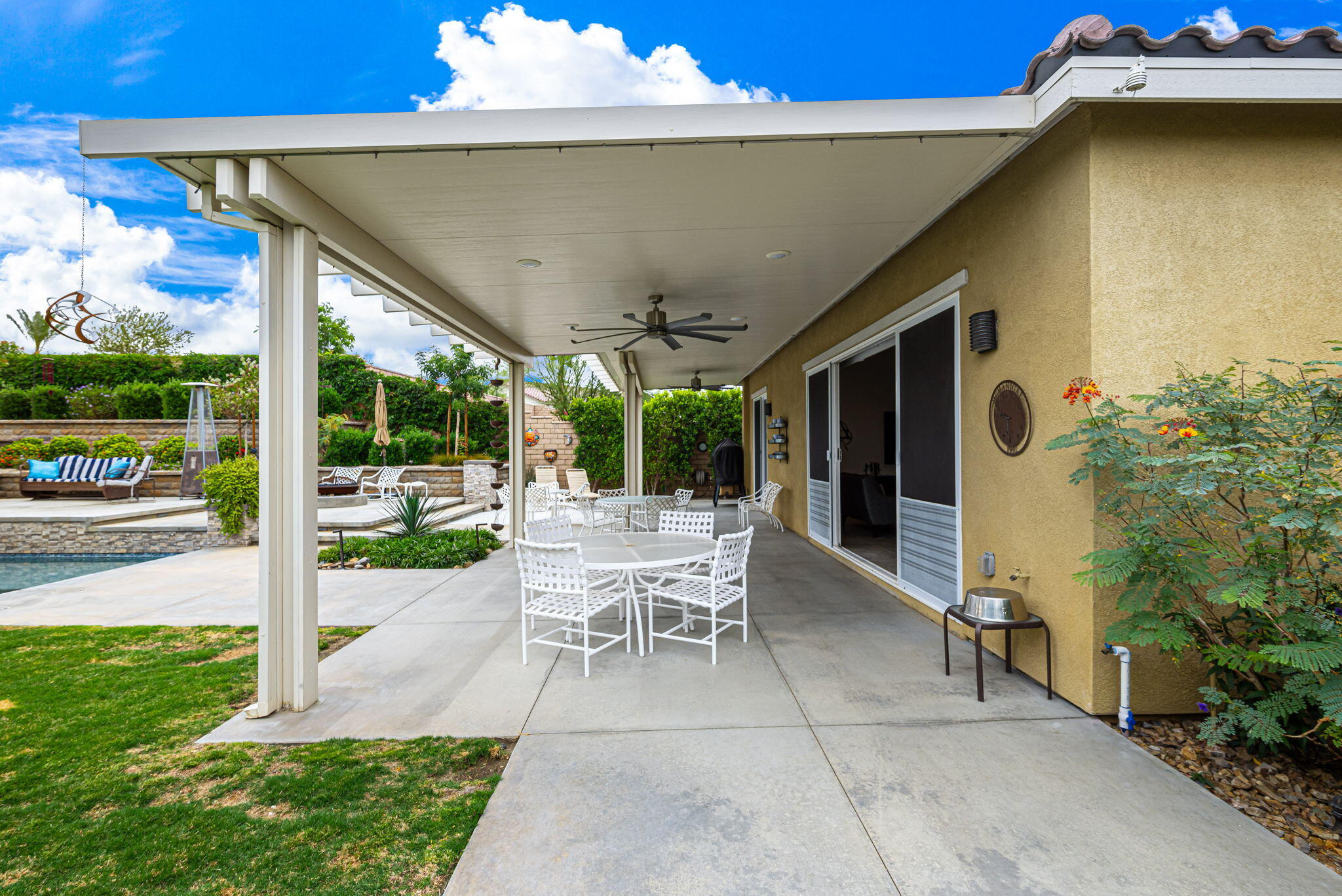 85568 Brovello Drive Indio, CA 92203 - Photo 42 of 50 a view of a patio with table and chairs potted plants with floor to ceiling window and potted plants
