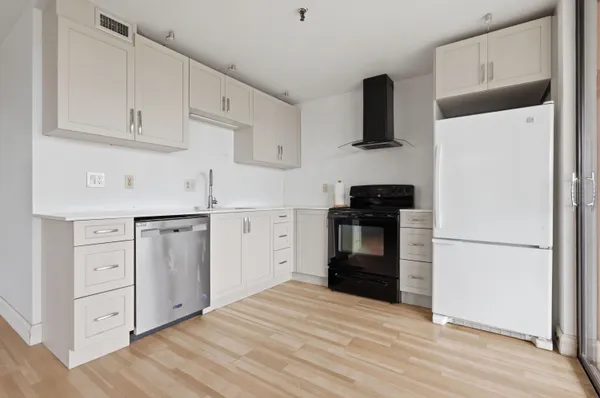 a kitchen with granite countertop a refrigerator stove and sink