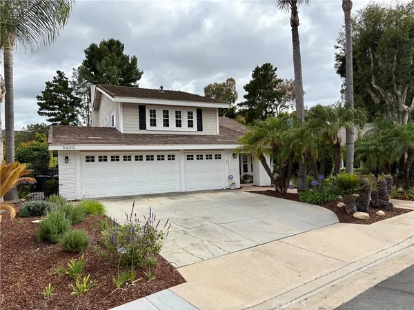 a view of a house with a yard and potted plants