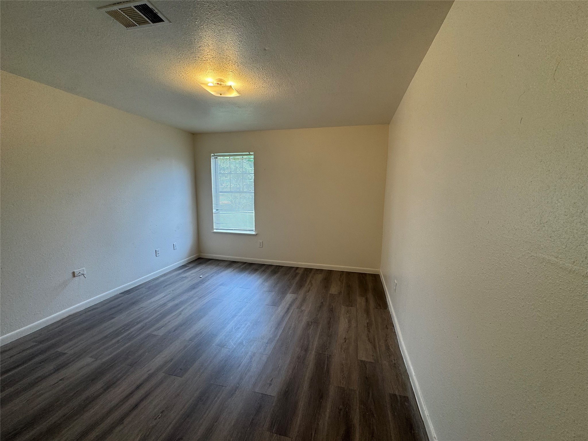 733 Pine Avenue Prairie View, TX 77445 - Photo 14 of 17 an empty room with wooden floor and windows