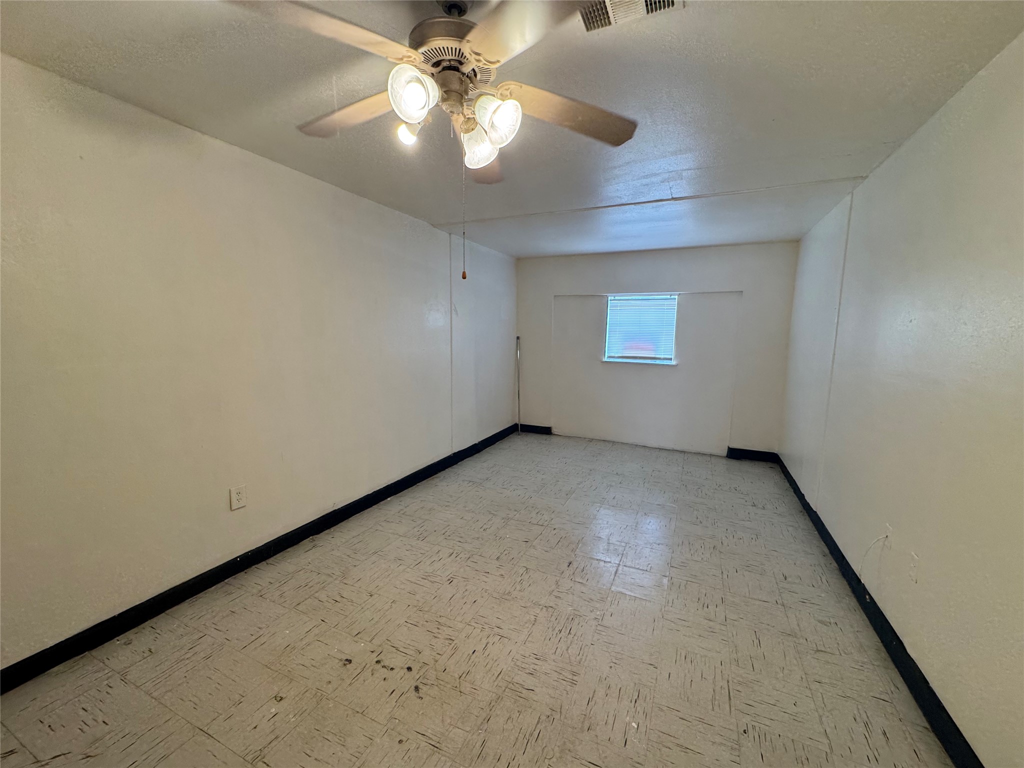 733 Pine Avenue Prairie View, TX 77445 - Photo 16 of 17 an empty room with a chandelier fan and windows