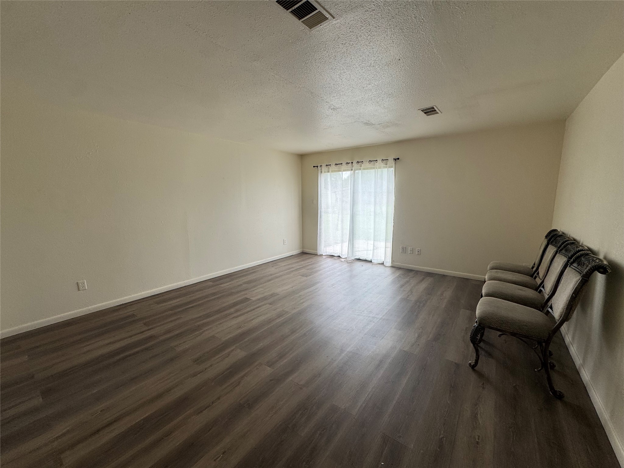 733 Pine Avenue Prairie View, TX 77445 - Photo 7 of 17 a view of an empty room with wooden floor and a window