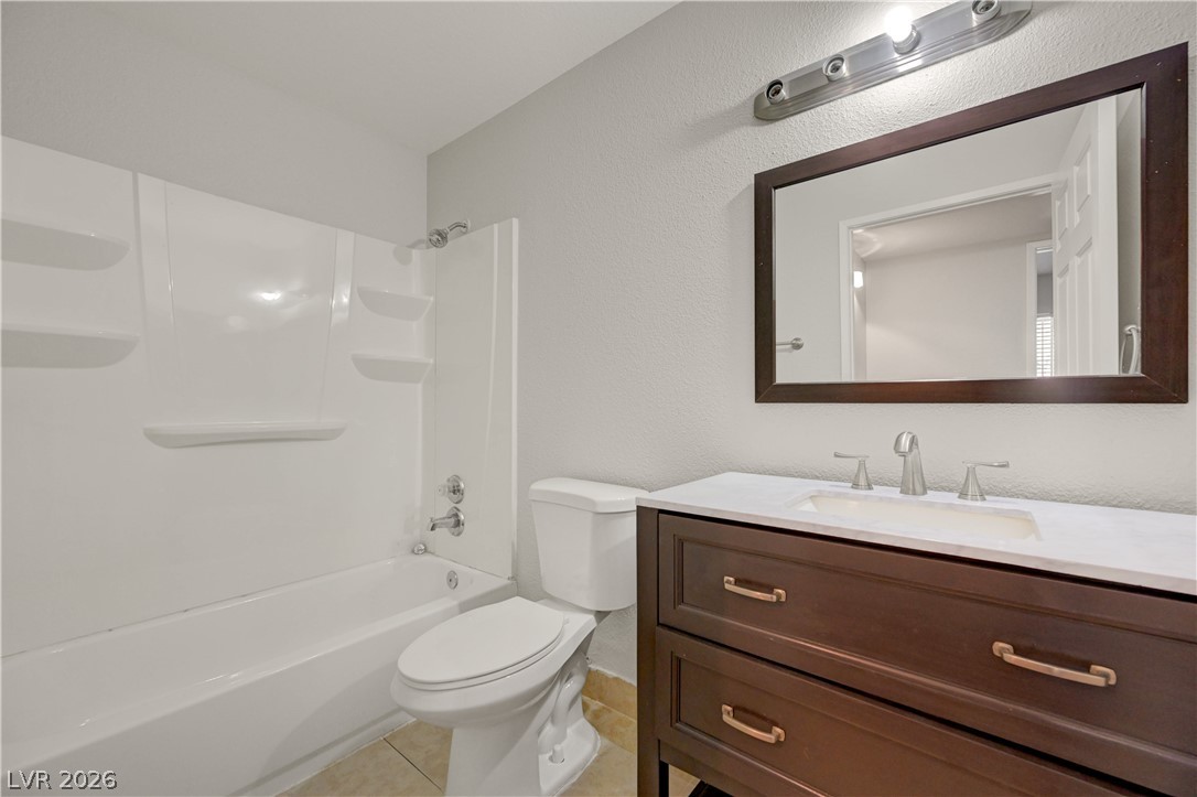 7885 West Flamingo Road, Unit 1050 Las Vegas, NV 89147 - Photo 31 of 62 A well-appointed bathroom features a dark wood vanity, white countertop, and clean tile flooring.