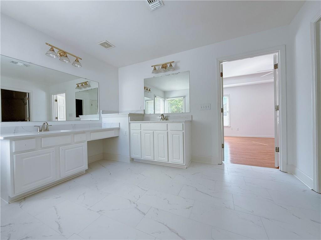 3332 Drawbridge Terrace Duluth, GA 30096 - Photo 16 of 28 a bathroom with a sink vanity granite tub and a mirror