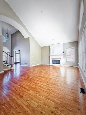 a view of empty room with kitchen and fireplace
