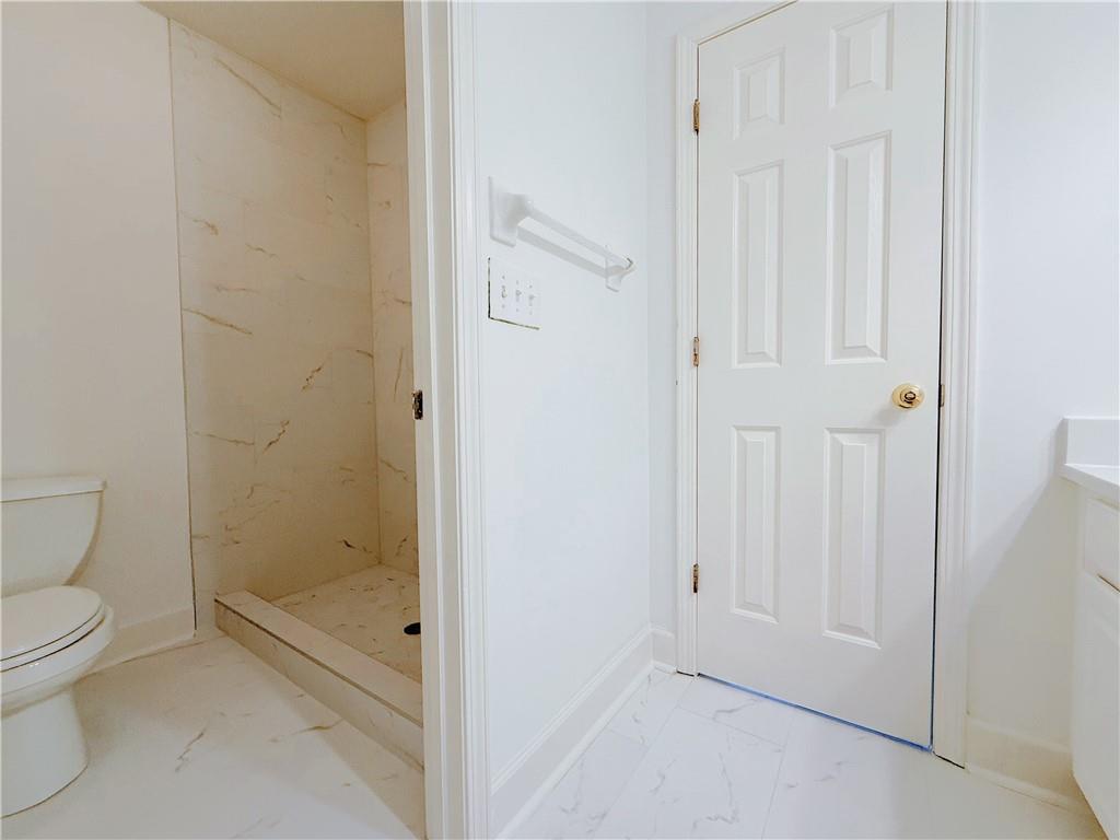 3332 Drawbridge Terrace Duluth, GA 30096 - Photo 21 of 28 a bathroom with a granite countertop toilet a sink and shower