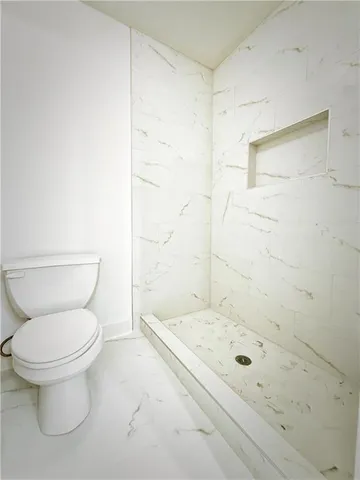 a bathroom with a granite countertop toilet a sink and shower