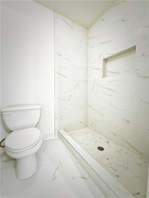 3332 Drawbridge Terrace Duluth, GA 30096 - Photo 22 of 28 a bathroom with a granite countertop toilet a sink and shower