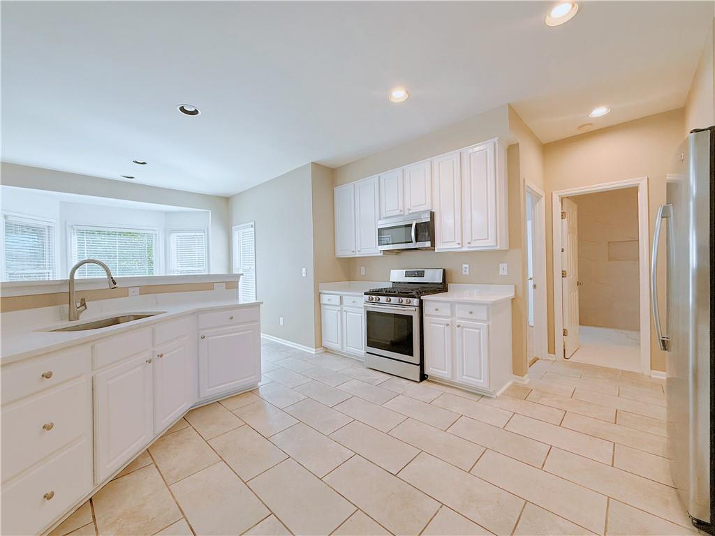 3332 Drawbridge Terrace Duluth, GA 30096 - Photo 8 of 28 a kitchen with white cabinets a sink and appliances