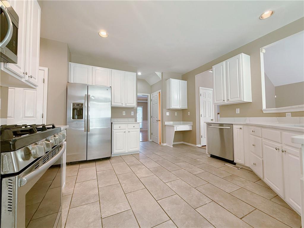 3332 Drawbridge Terrace Duluth, GA 30096 - Photo 9 of 28 a kitchen with white cabinets and appliances