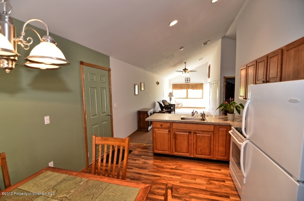 372 Marshal Squire Road Nicholson, PA 18446 - Photo 54 of 80 a kitchen with stainless steel appliances granite countertop a sink a stove a refrigerator with white cabinets and wooden floor