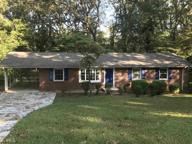 a front view of a house with a yard and trees
