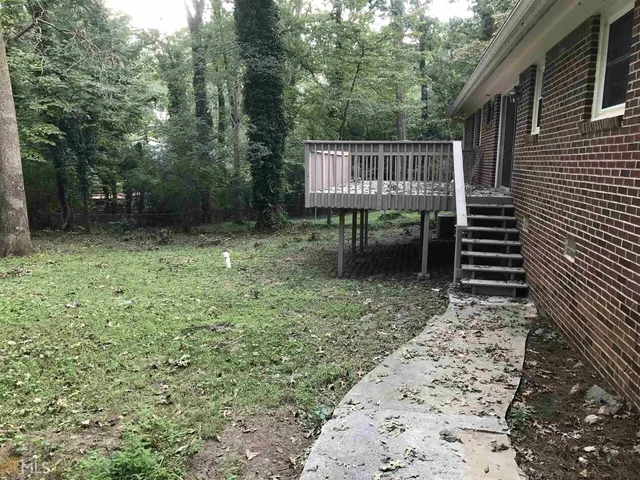 a view of backyard with a garden and deck