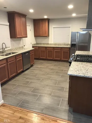a large kitchen with granite countertop a sink and cabinets