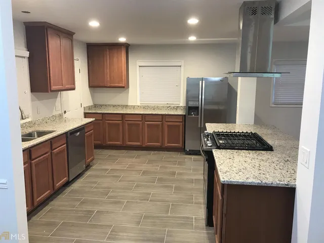a kitchen with stainless steel appliances granite countertop a sink stove and refrigerator
