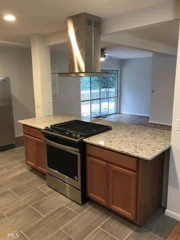 a kitchen with granite countertop a stove and a sink