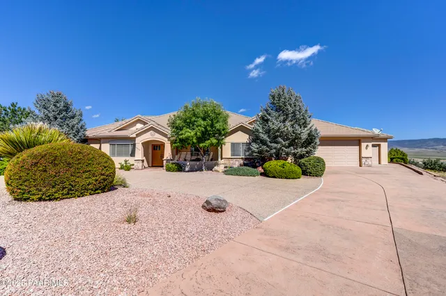 a view of a house with a yard and potted plants