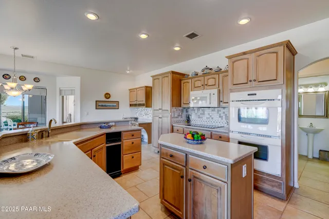 a large kitchen with granite countertop a sink and a refrigerator