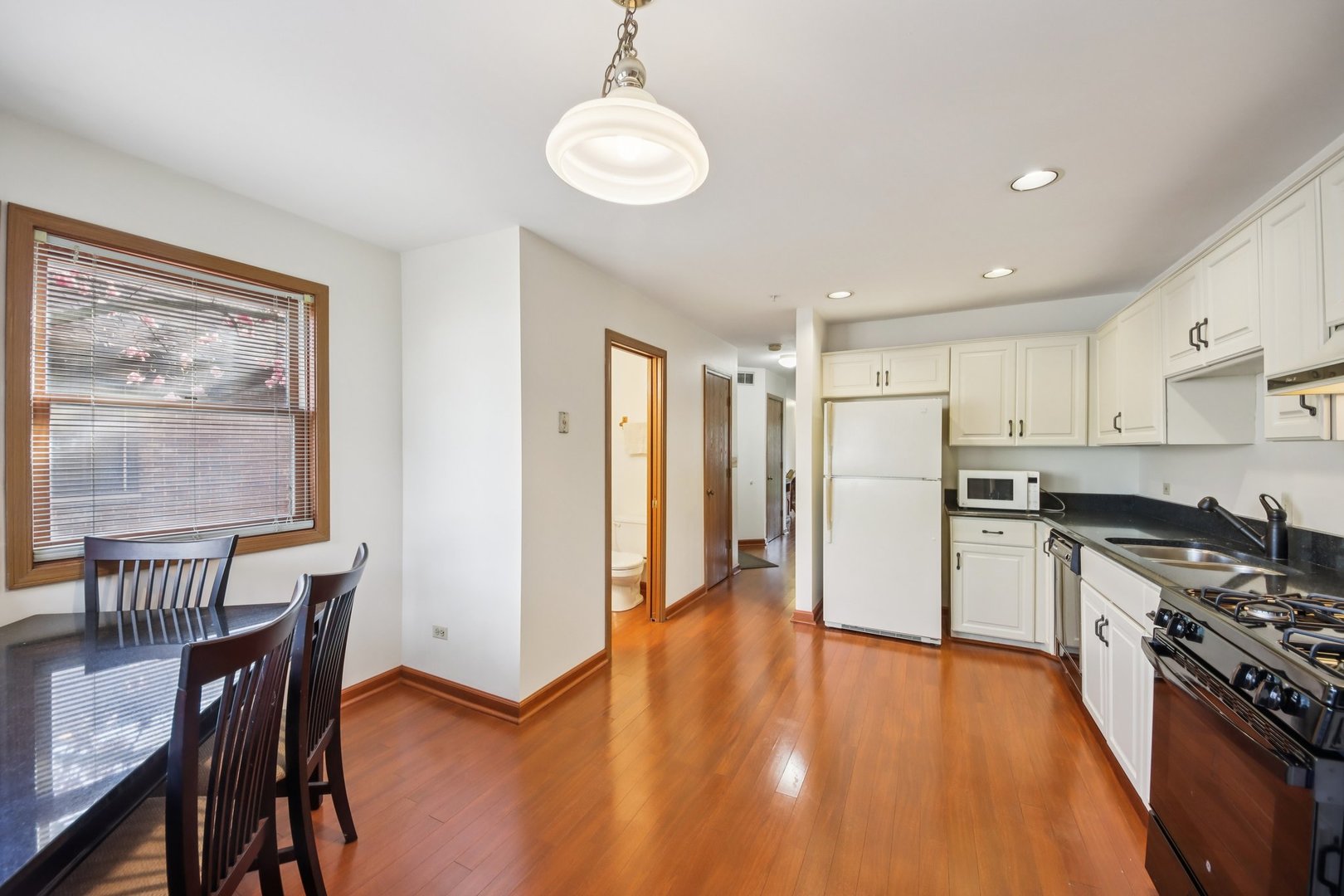 37 Terrace Lane, Unit F Lake Zurich, IL 60047 - Photo 12 of 40 a kitchen with stainless steel appliances a stove a refrigerator a dining table and chairs