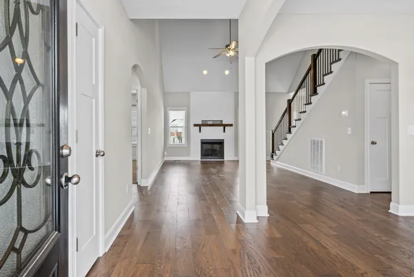 a view of a hallway with wooden floor and staircase
