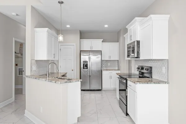 a kitchen with stainless steel appliances granite countertop a sink a stove a refrigerator a center island a stove and cabinets