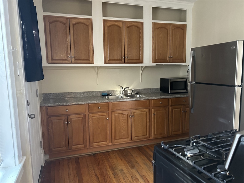 1719 Northampton Street, Unit 3 Holyoke, MA 01040 - Photo 2 of 11 a kitchen with stainless steel appliances granite countertop a refrigerator stove and sink with wooden floor