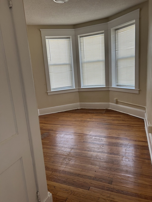 1719 Northampton Street, Unit 3 Holyoke, MA 01040 - Photo 5 of 11 a view of empty room with wooden floor and fan