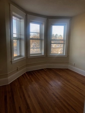1719 Northampton Street, Unit 3 Holyoke, MA 01040 - Photo 7 of 11 an empty room with wooden floor and windows