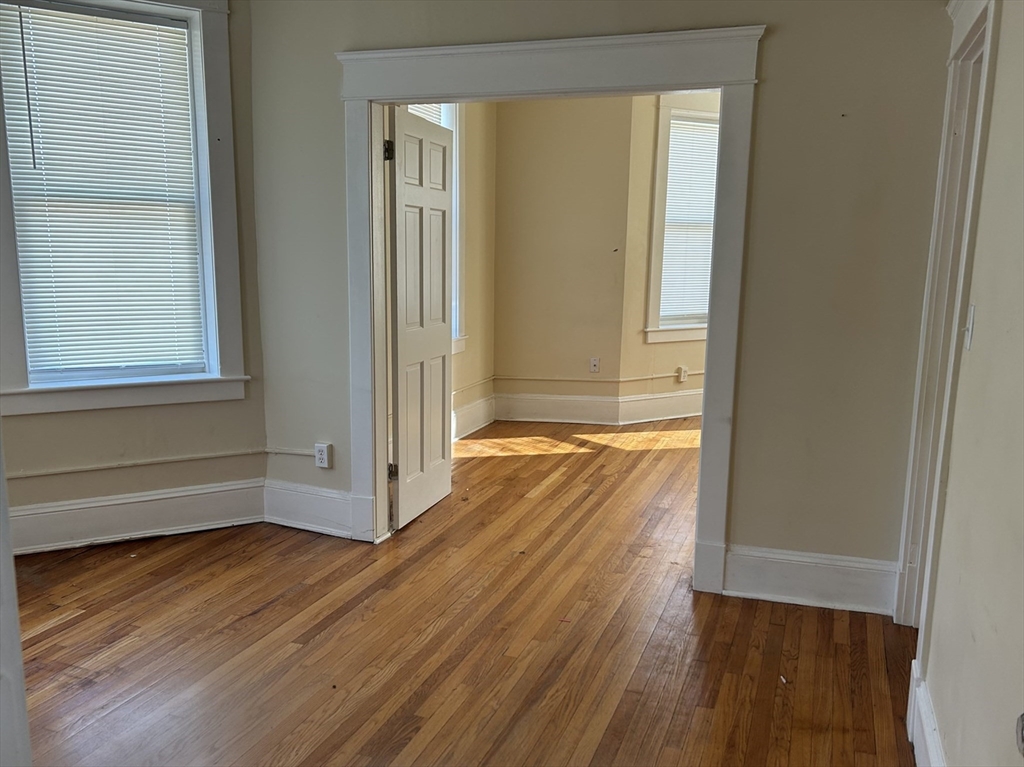 1719 Northampton Street, Unit 3 Holyoke, MA 01040 - Photo 9 of 11 an empty room with wooden floor and windows