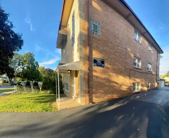 a view of a brick building next to a yard