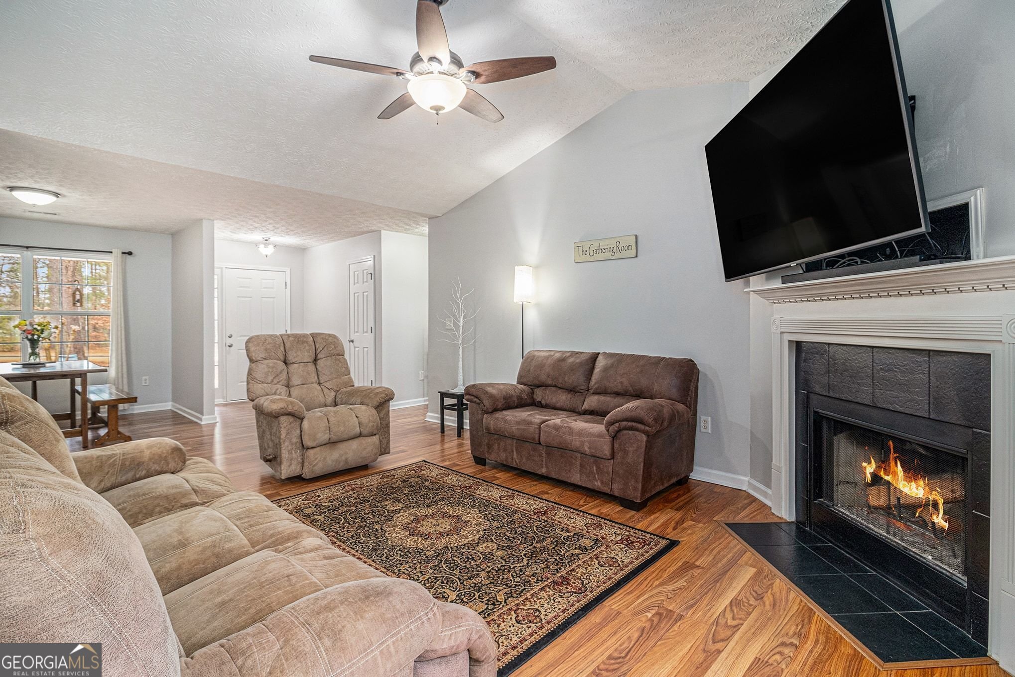 30 Old Mill Way Senoia, GA 30276 - Photo 14 of 29 a living room with furniture a fireplace and a flat screen tv