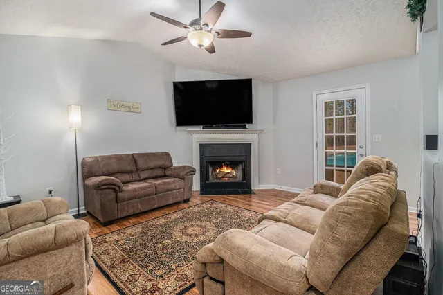 a living room with furniture a flat screen tv and a fireplace